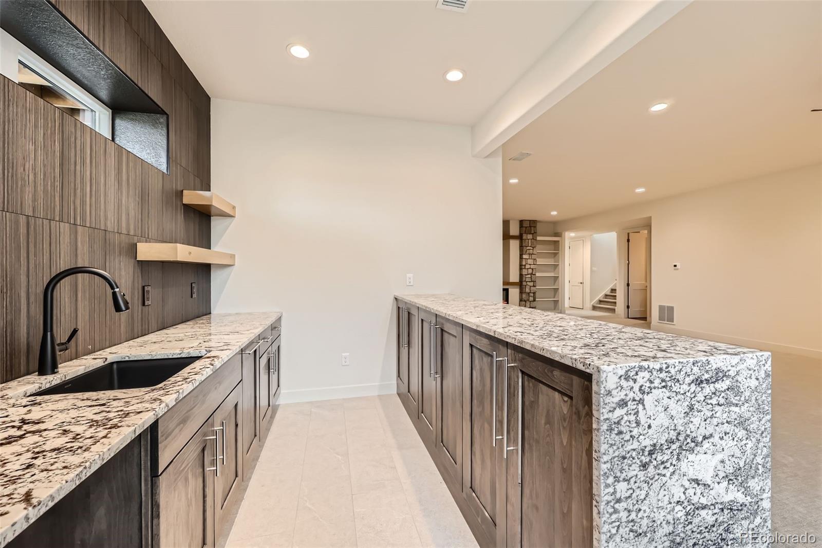 5841 Powell Road Parker, CO 80134 - Photo 35 of 50 a kitchen with granite countertop a sink a stove top oven and cabinets