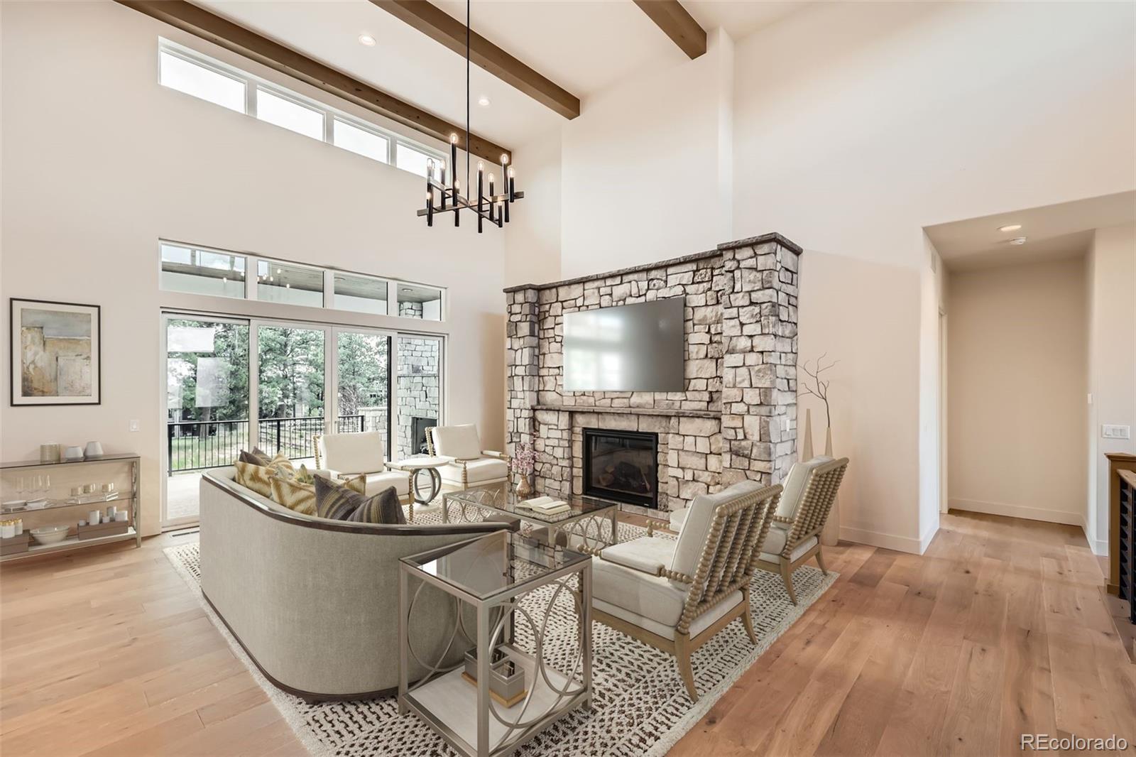 5841 Powell Road Parker, CO 80134 - Photo 45 of 50 a living room with furniture a fireplace and a chandelier