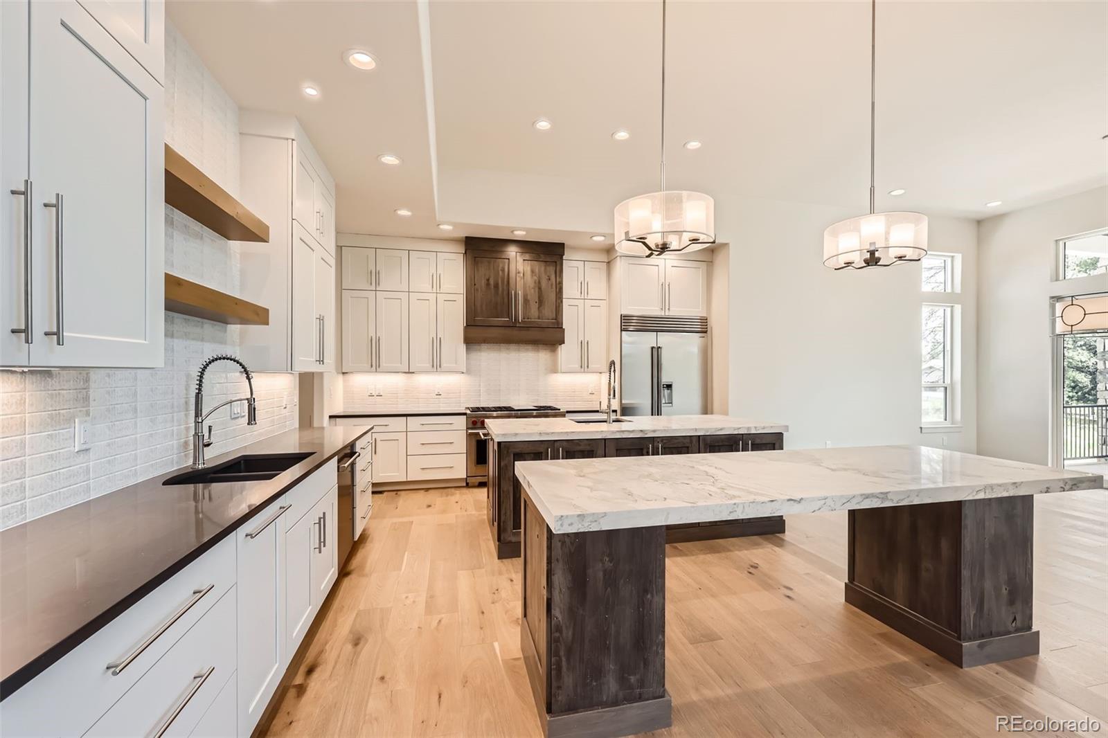 5841 Powell Road Parker, CO 80134 - Photo 10 of 50 a open kitchen with stainless steel appliances granite countertop a sink stove and refrigerator
