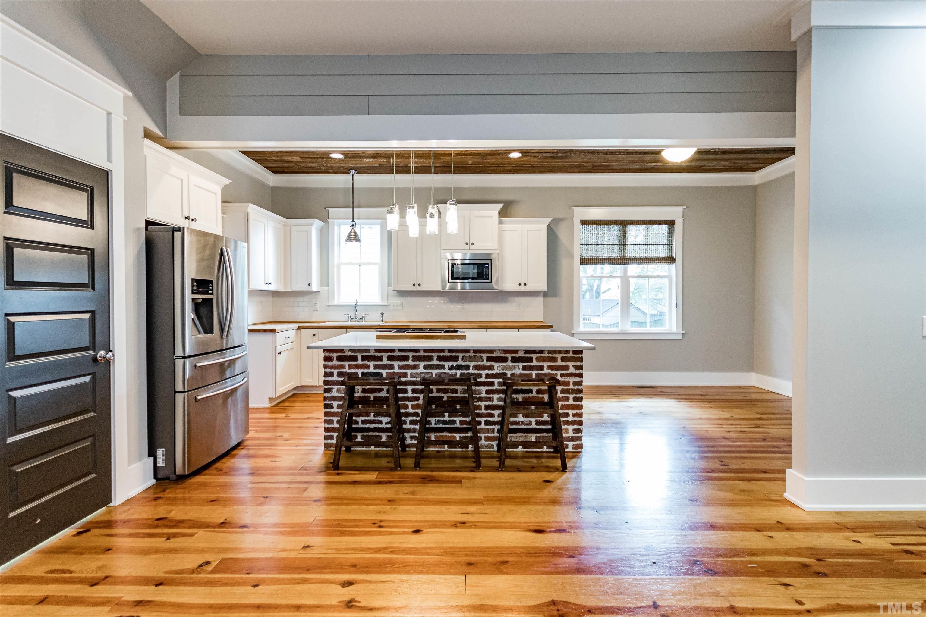 610 New Road Raleigh, NC 27608 - Photo 11 of 24 a view of kitchen with refrigerator and wooden floor