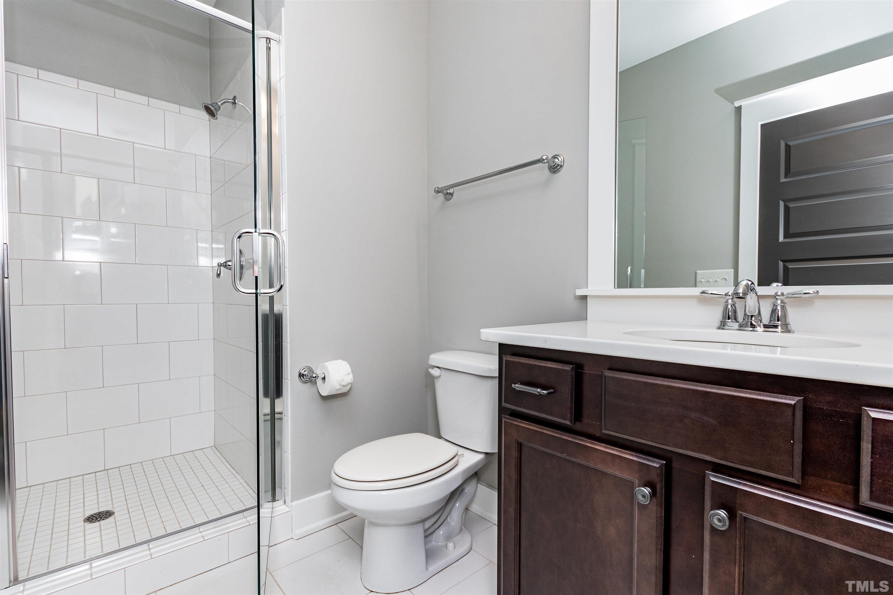 610 New Road Raleigh, NC 27608 - Photo 19 of 24 a bathroom with a sink a toilet and shower