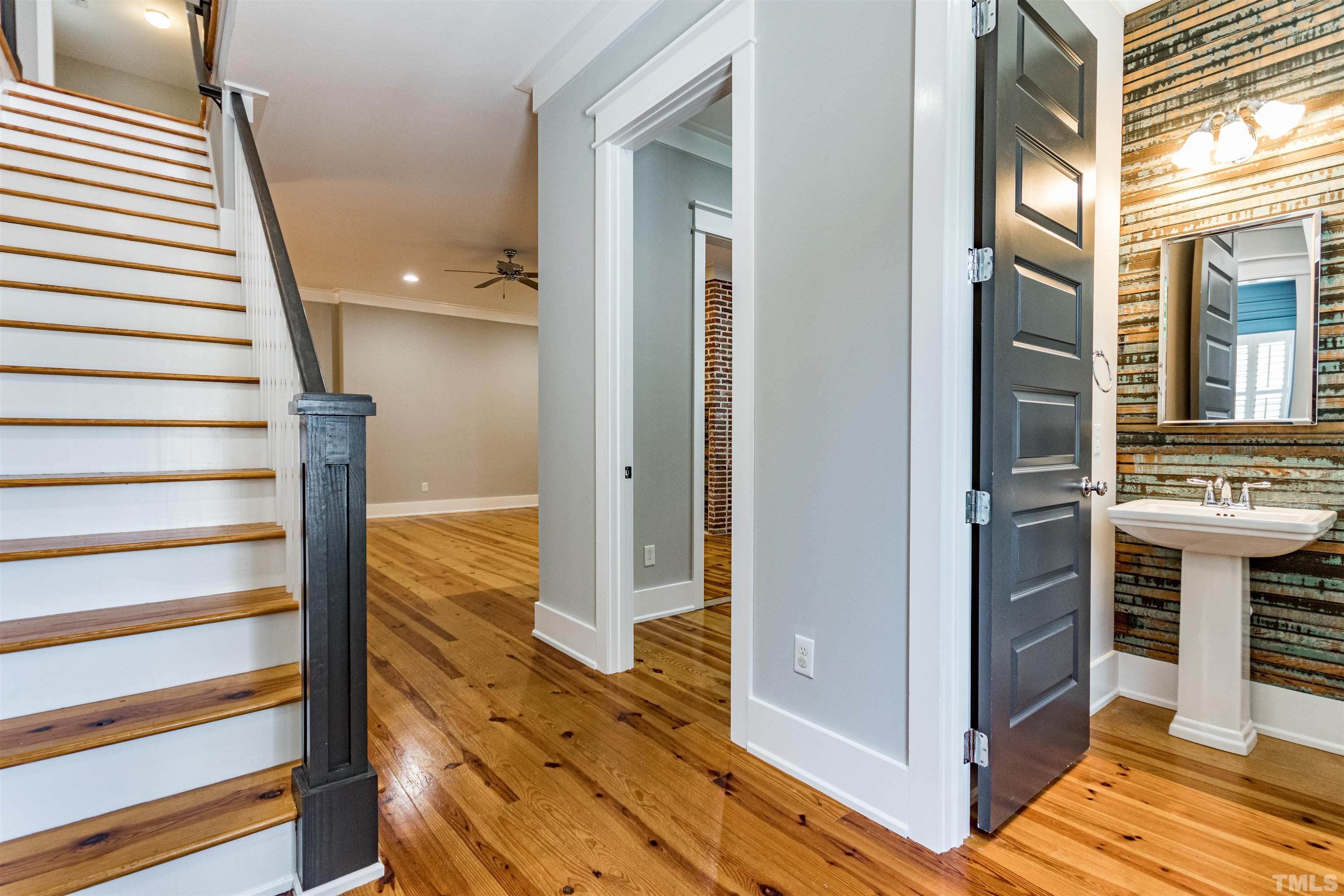 610 New Road Raleigh, NC 27608 - Photo 4 of 24 a view of a hallway with wooden floor and staircase