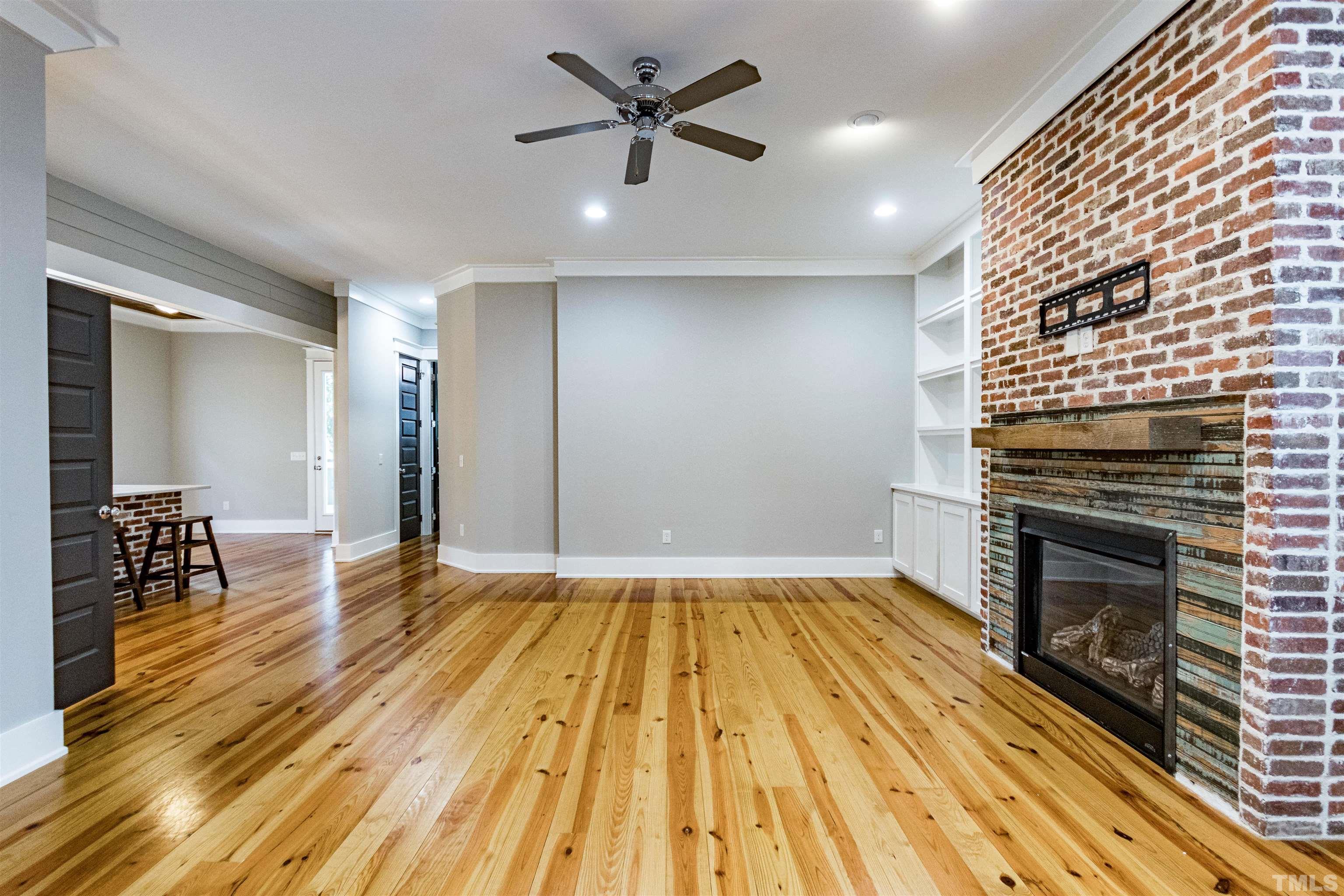 610 New Road Raleigh, NC 27608 - Photo 6 of 24 a view of empty room with a fireplace and wooden floor