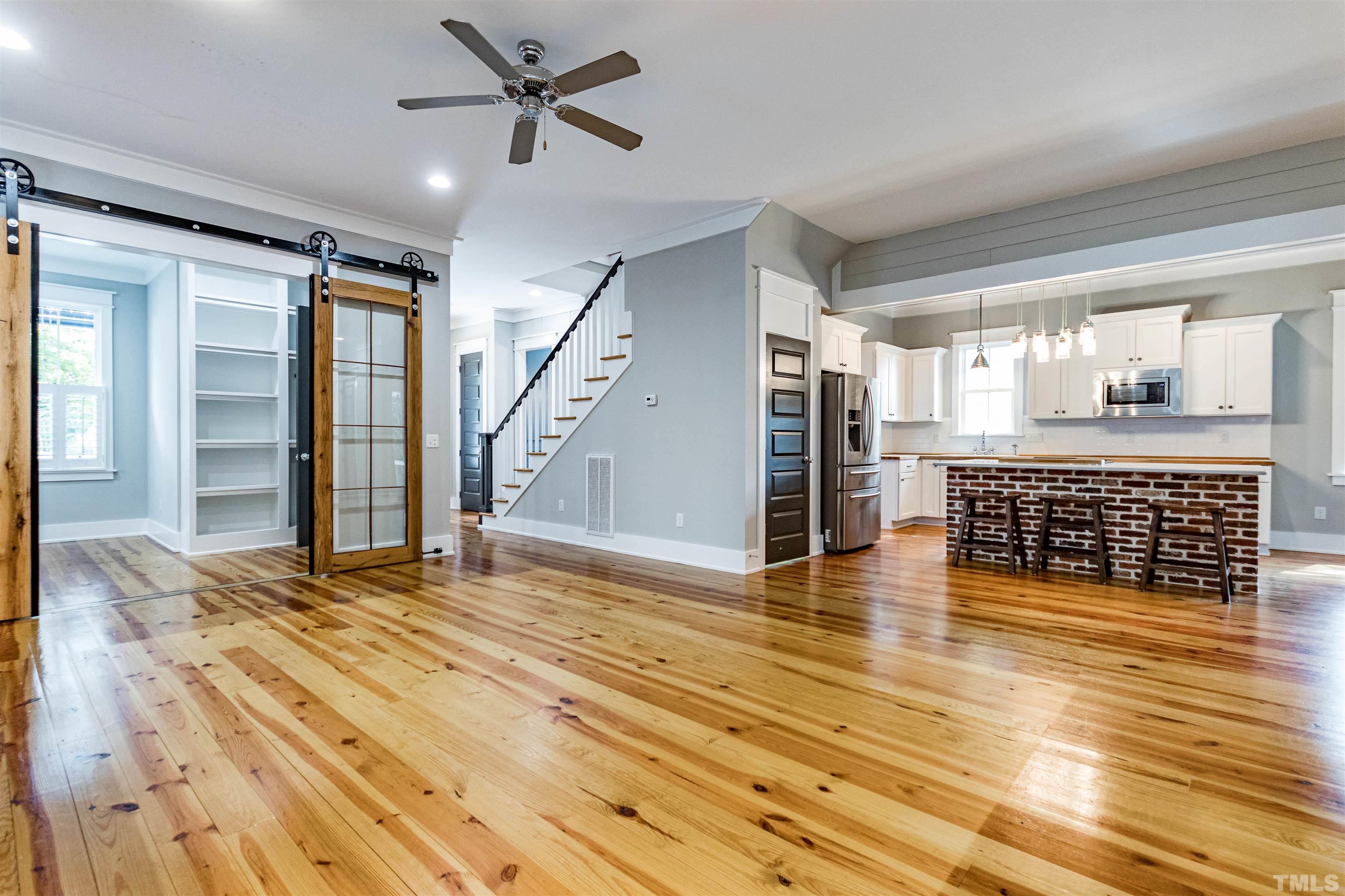 610 New Road Raleigh, NC 27608 - Photo 7 of 24 a view of a livingroom with wooden floor and a ceiling fan