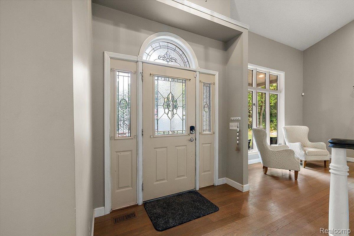 707 West Sutton Road Metamora, MI 48455 - Photo 22 of 84 Entryway featuring a decorative transom and sidelights, wood-finish flooring, and a large multi-pane window