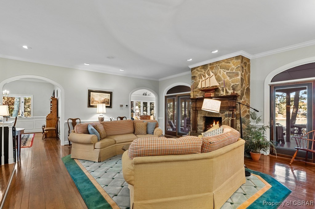 184 York Road Irvington, VA 22480 - Photo 11 of 46 Living room with hardwood / wood-style flooring, a stone fireplace, and crown molding
