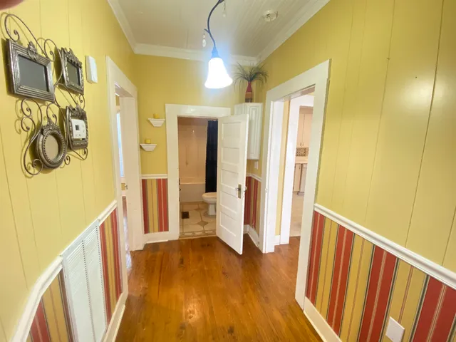 a view of a hallway with wooden floor and staircase