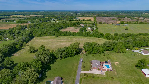 an aerial view of a houses with a yard and lake view