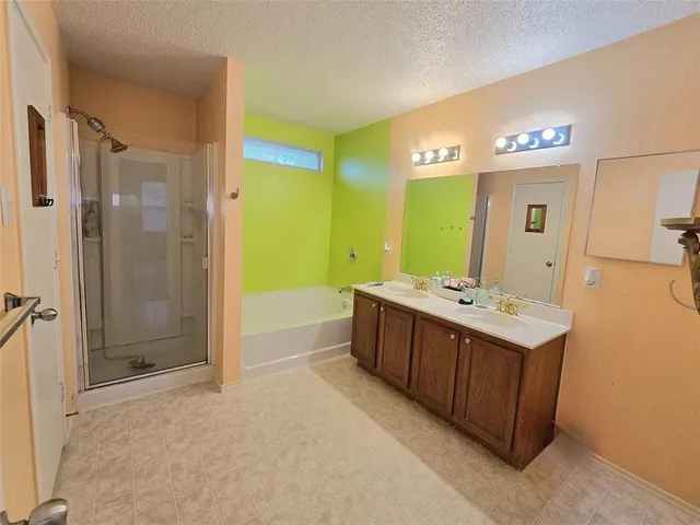 a bathroom with a tub sink shower and mirror