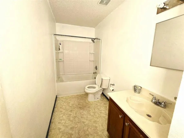 a bathroom with a granite countertop sink a toilet and shower