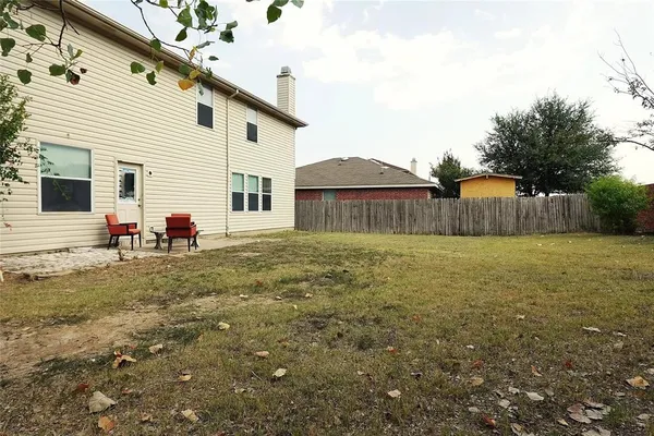 a view of a backyard with table and chairs and wooden fence