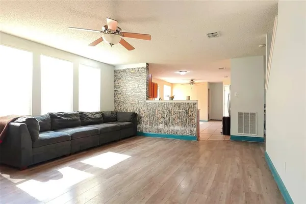 a living room with furniture and a wooden floor