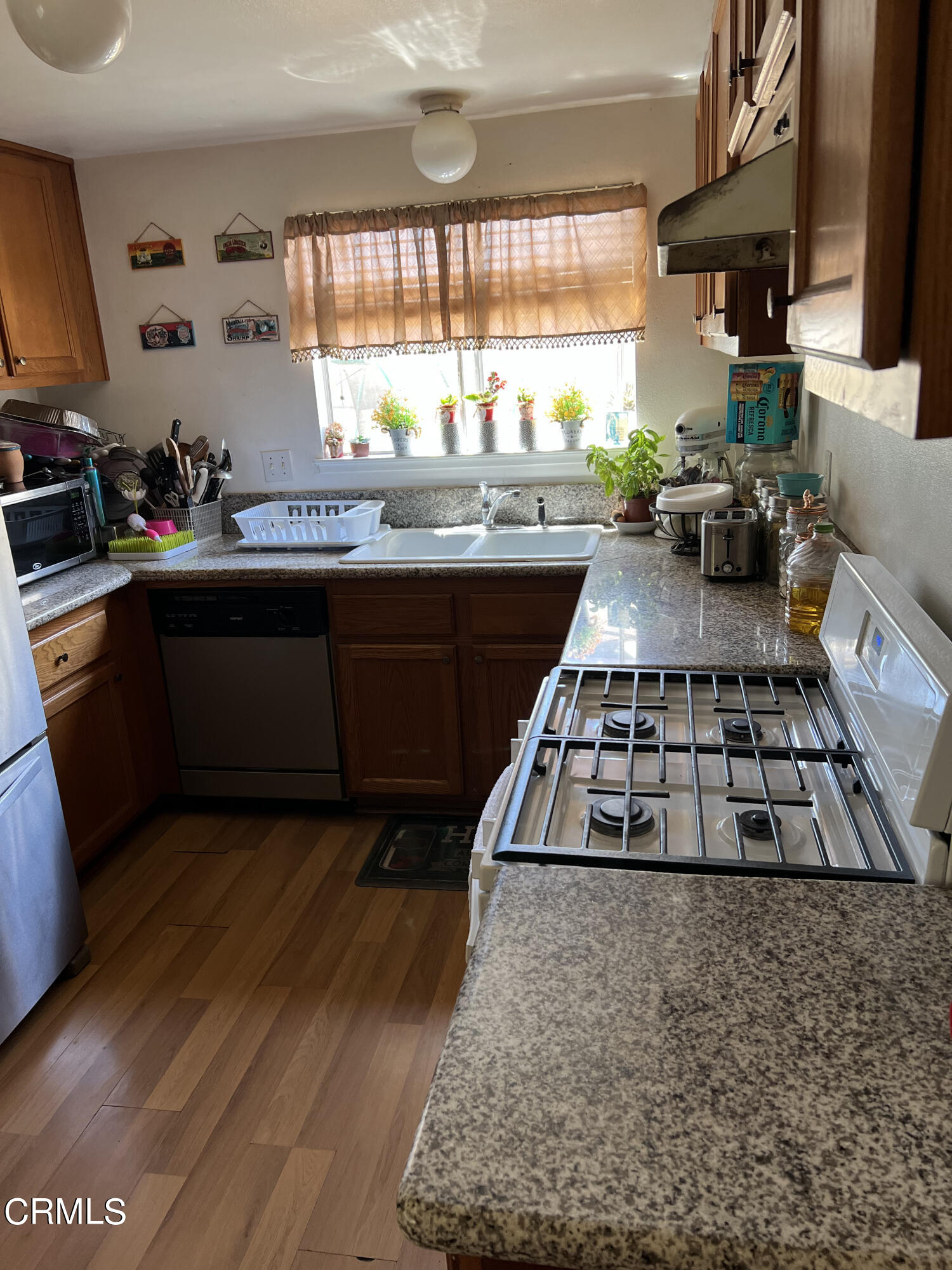 2060 Falkner Place Oxnard, CA 93033 - Photo 2 of 12 a kitchen with granite countertop a stove a sink and a microwave
