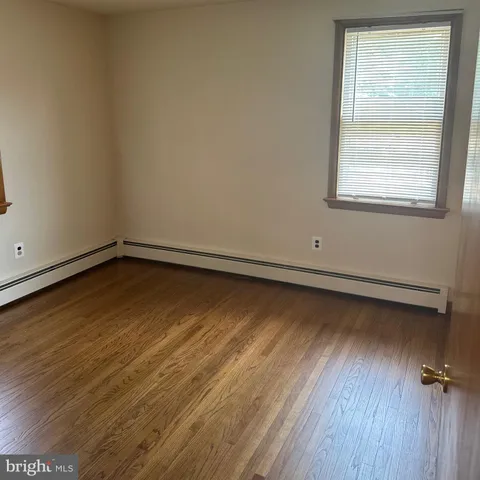 an empty room with a hardwood and windows