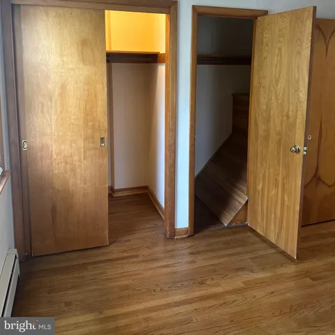 an empty room with wooden floor and entrance