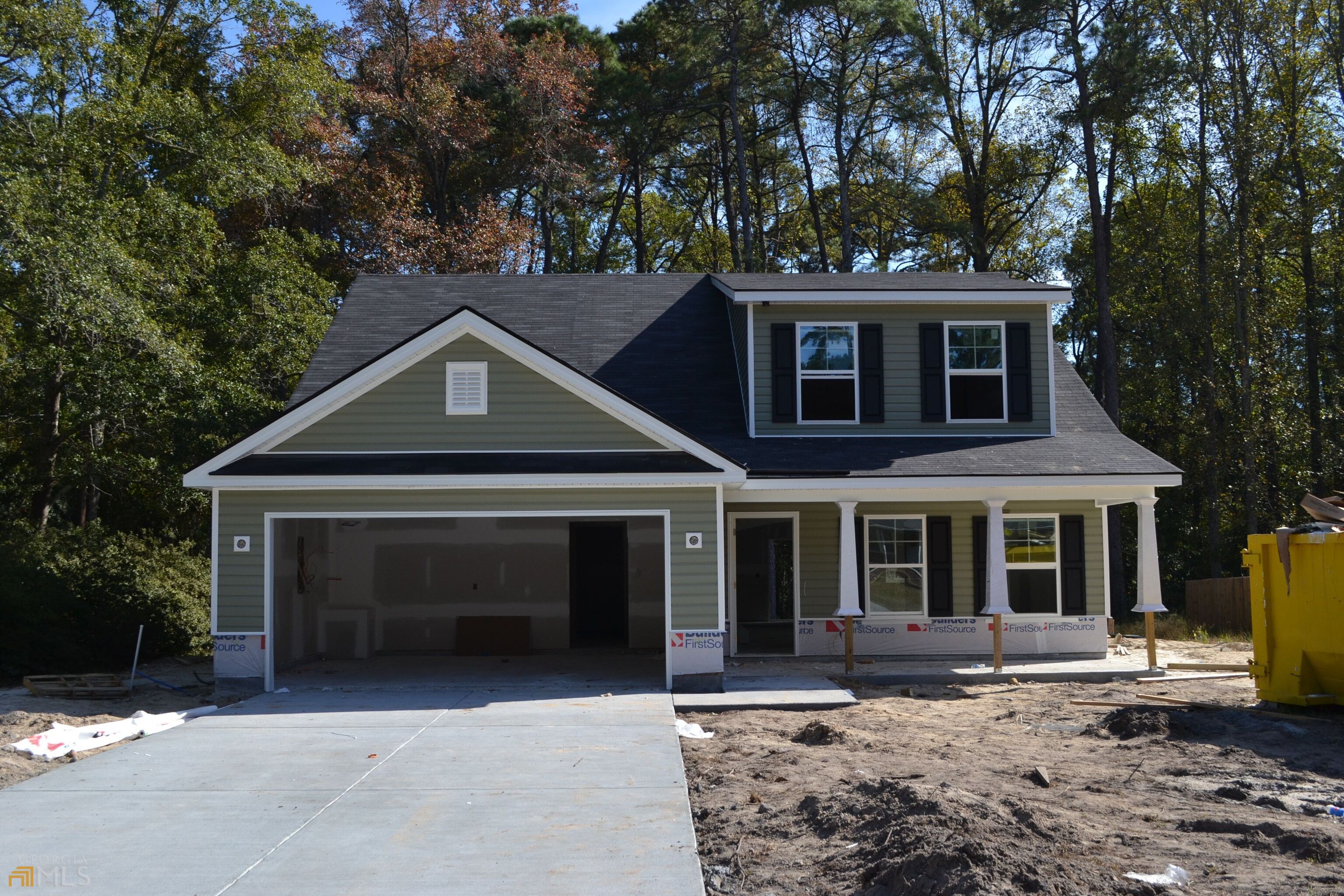 115 Shaw Street, Unit B Rincon, GA 31326 - Photo 1 of 1 a front view of a house with a garden and trees