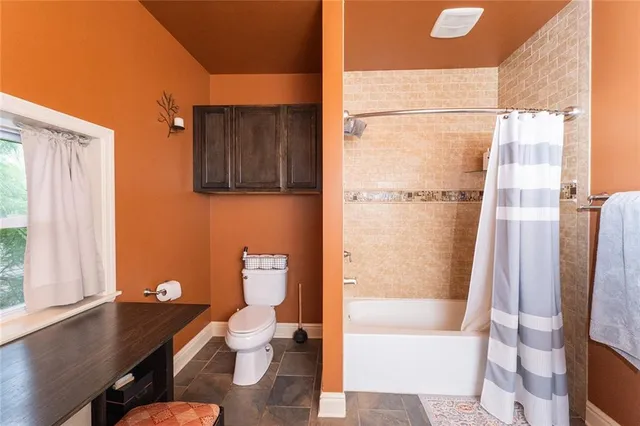 a bathroom with a granite countertop bathtub shower sink and toilet