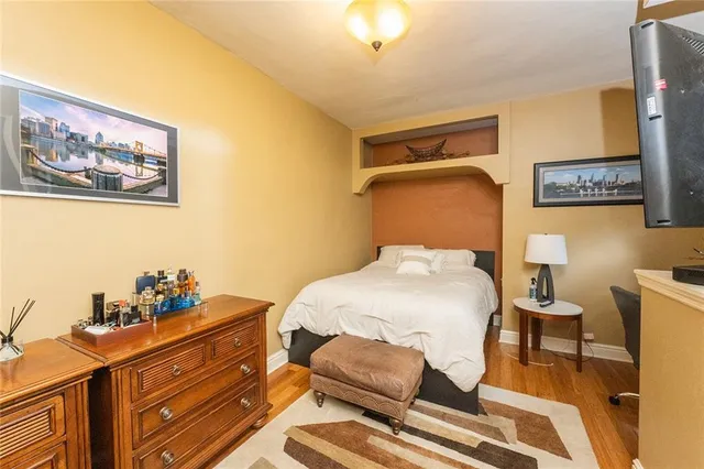 a bedroom with a bed and wooden floor