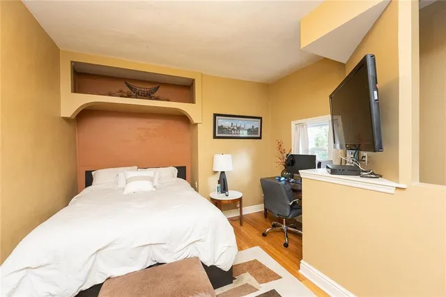 a bedroom with a bed and large windows