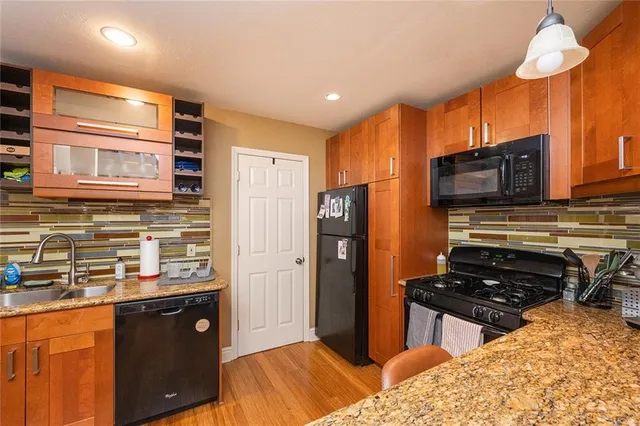 a kitchen with stainless steel appliances granite countertop a refrigerator and a stove top oven