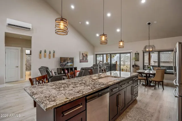 a kitchen with granite countertop a stove a sink a dining table and chairs