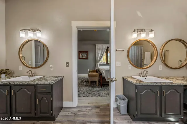 a bathroom with a granite countertop double vanity sink and a mirror