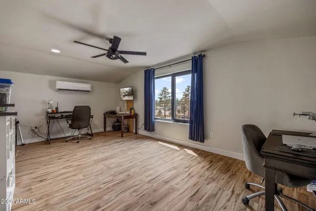 a view of a workspace with furniture and a window