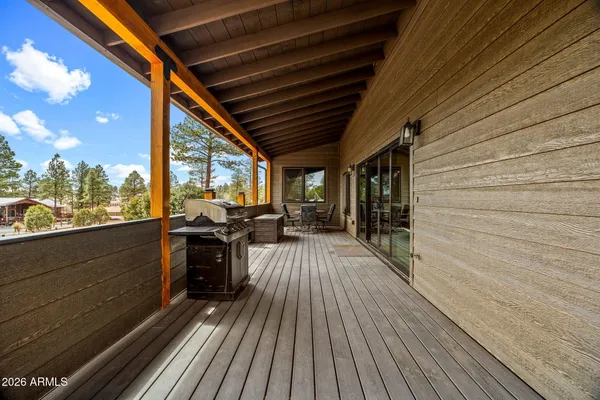 a view of a balcony with chairs and wooden floor