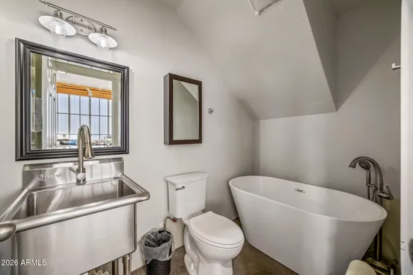 a bathroom with a sink and mirror with toilet