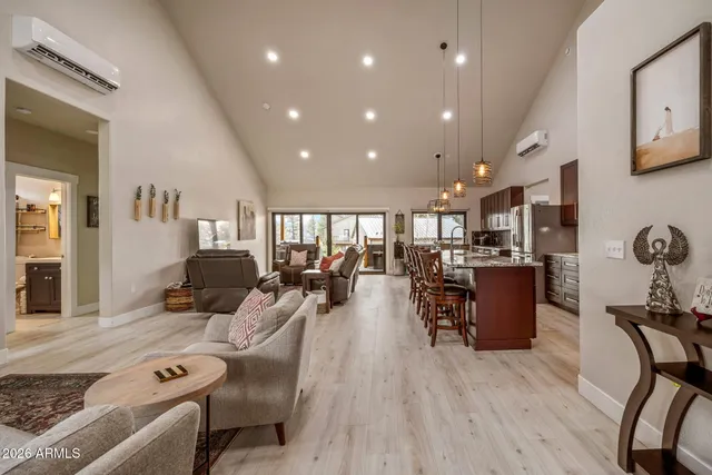 a living room with furniture a wooden floor and a large window