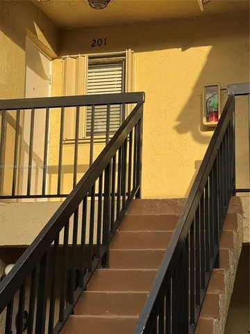 a view of staircase with wooden floor and white walls
