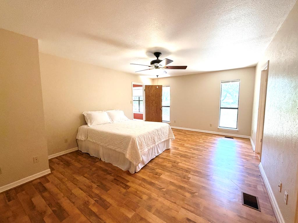 707 Rimrock Road Kerrville, TX 78028 - Photo 26 of 55 a spacious bedroom with a bed and wooden floor