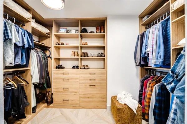 a view of walk in closet with clothes and shoes