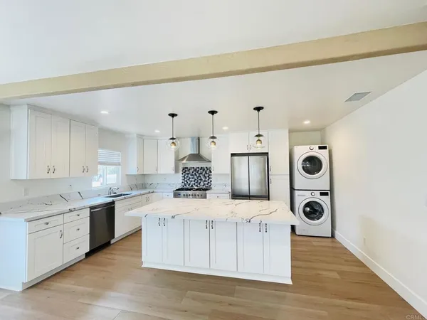 a large kitchen with stainless steel appliances granite countertop a stove a sink and a refrigerator