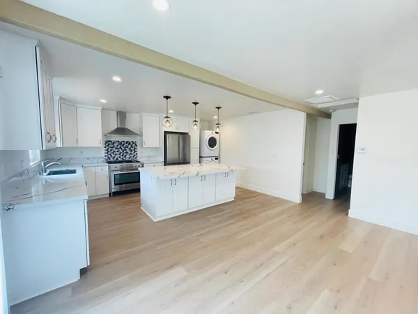 a view of a kitchen with furniture and wooden floor