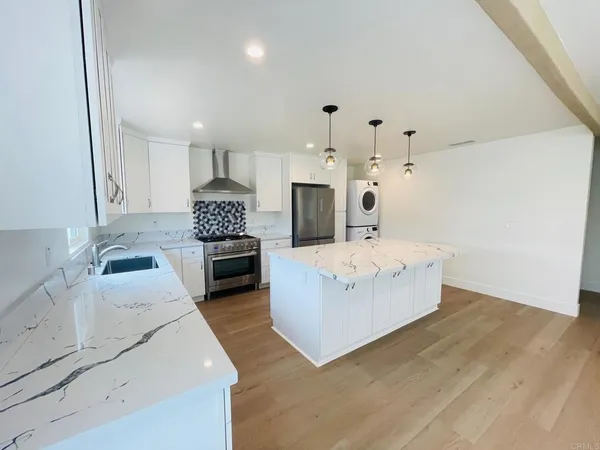 a large kitchen with sink a microwave a stove and refrigerator