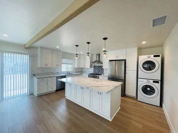 a view of a kitchen with wooden floor and electronic appliances