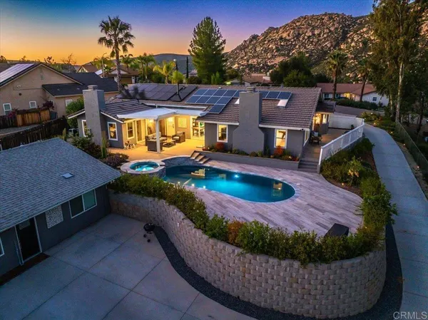 a view of a house with a swimming pool and sitting area