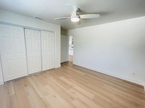 a view of an empty room with a ceiling fan