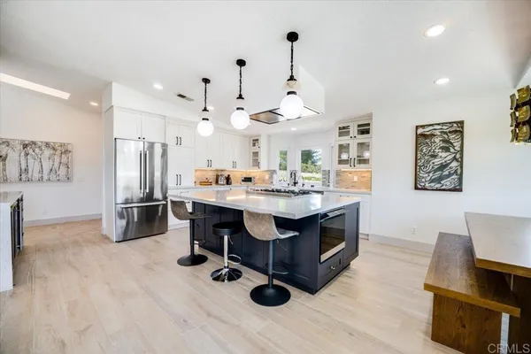 a kitchen with stainless steel appliances kitchen island hardwood floor sink and stove