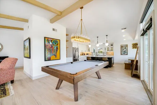 a room with table chairs and kitchen view