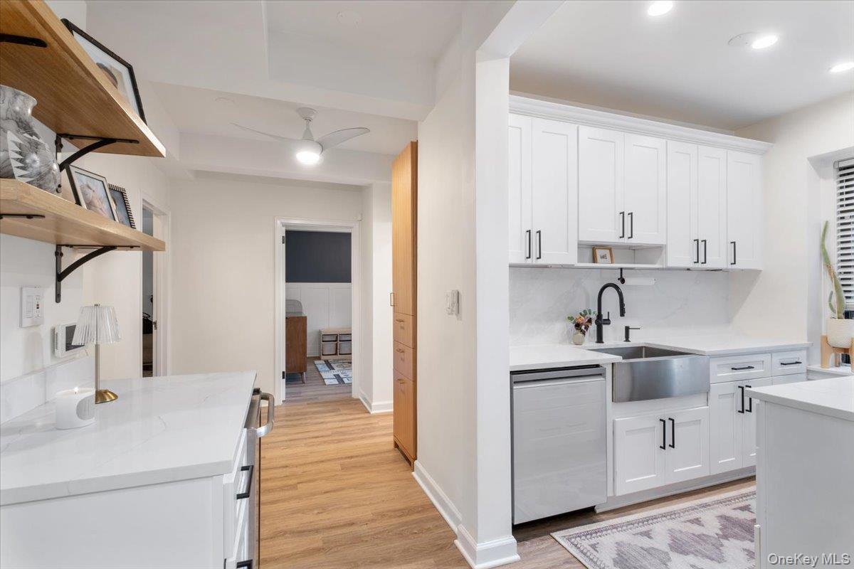 a kitchen with white cabinets and sink
