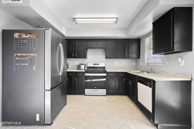 a kitchen with stainless steel appliances granite countertop a refrigerator and a stove top oven