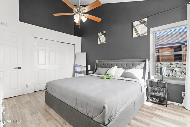 a spacious bedroom with a bed and a chandelier