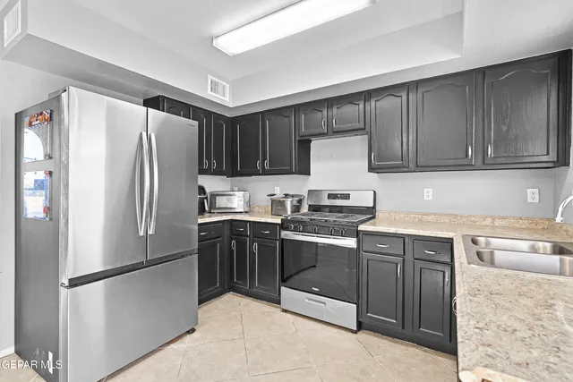 a kitchen with a refrigerator sink and cabinets