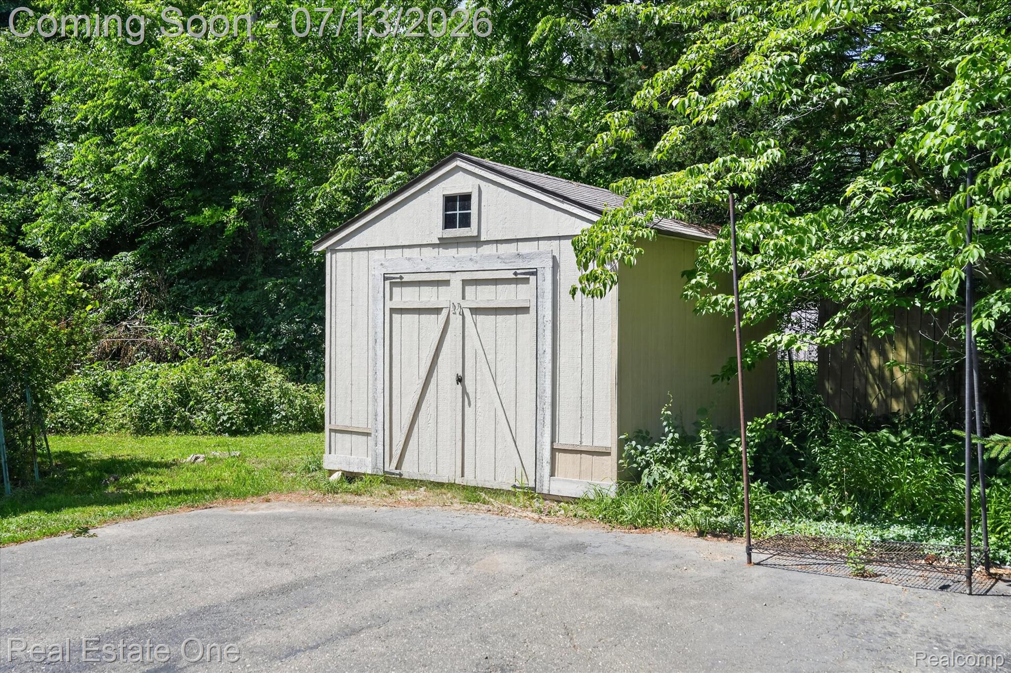 6039 Fish Lake Road Holly, MI 48442 - Photo 51 of 70 Gable-roof storage shed with a small attic window and double barn doors, with an additional shed behind.
