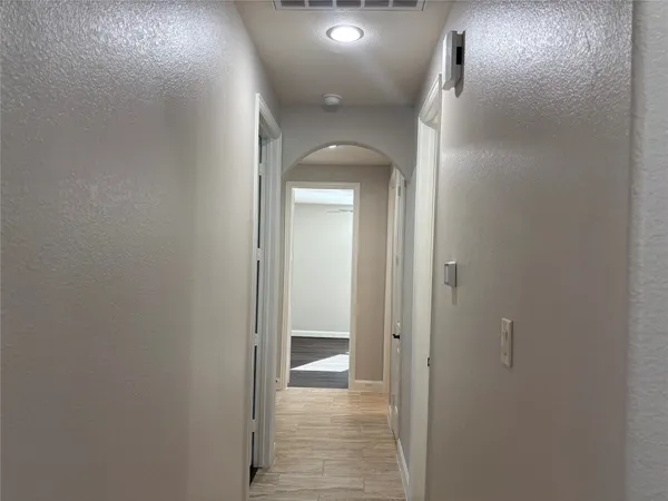 a view of a hallway with wooden floor