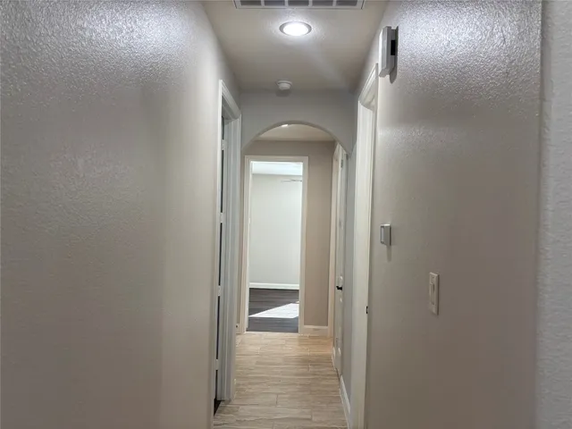 a view of a hallway with wooden floor