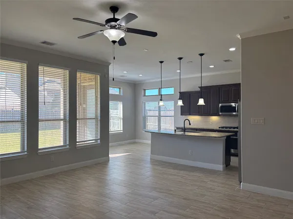 a open kitchen with stainless steel appliances granite countertop a stove a sink a center island and a window