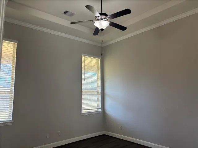 an empty room with a window and a fan